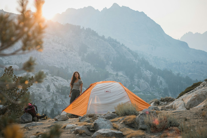 Backpacker changing into dry layers at camp